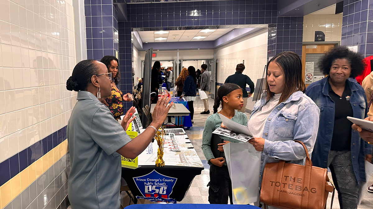 staff-speaking-to-parent-at-community-event