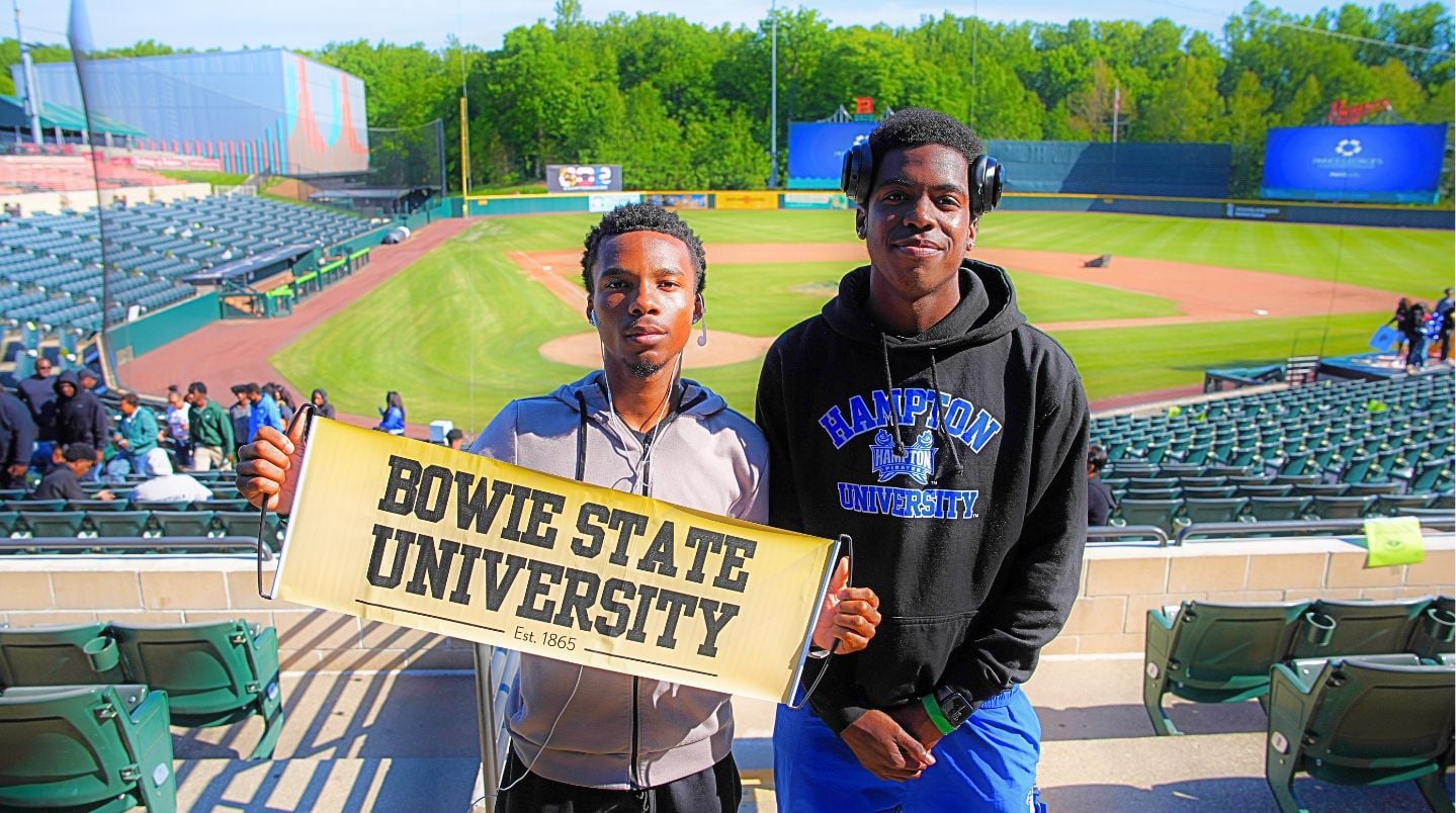 graduates-holding-Bowie-State-University-banner