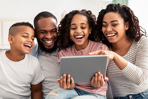 parents-adults-kids-family-in-group-looking-at-tablet-smiling